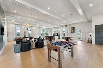 A spacious living room with a large wooden table and comfortable seating.